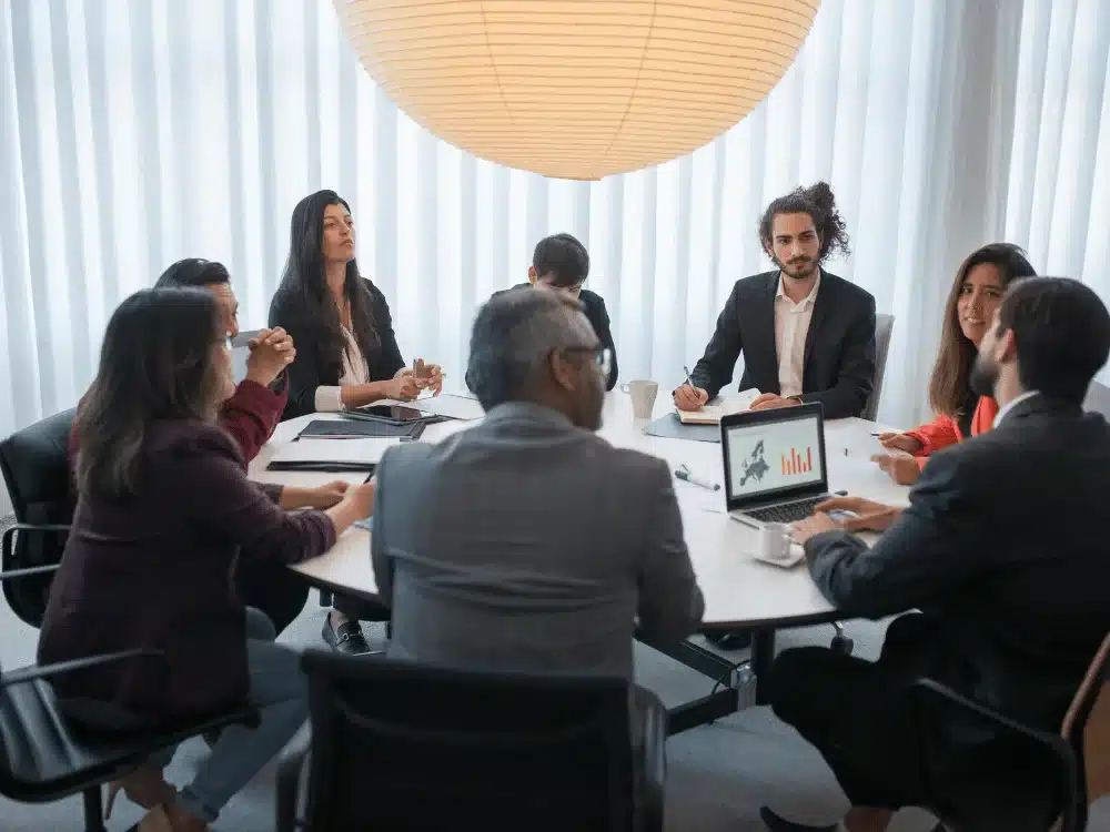A diverse group of professionals in a business meeting around a conference table.