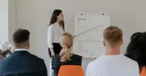 Businesswoman giving a presentation with a flip chart in front of colleagues.
